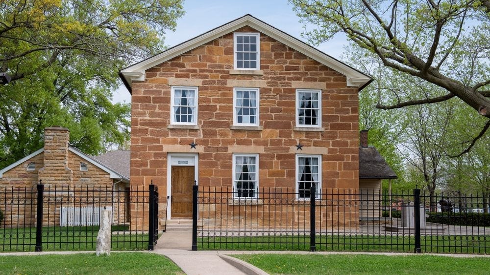 Brick building, two stories, with several windows and front door.